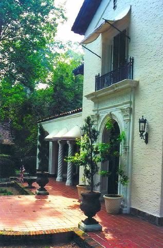 A white building with a balcony and potted plants