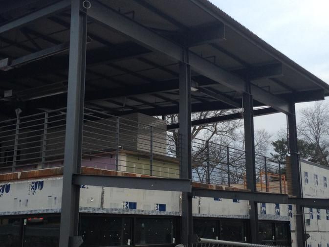 a building under construction with a balcony and a roof