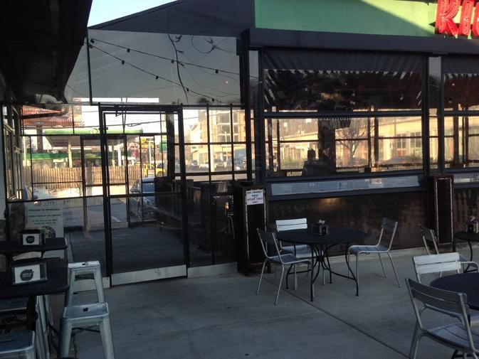 the outside of a restaurant with tables and chairs