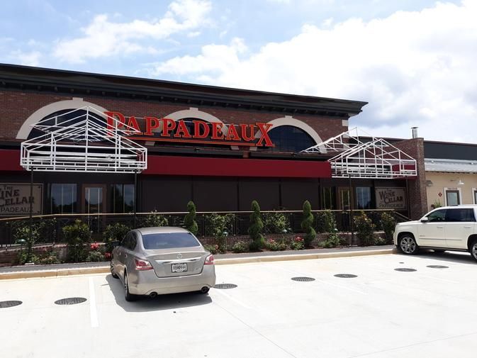 a couple of cars are parked in front of a restaurant .