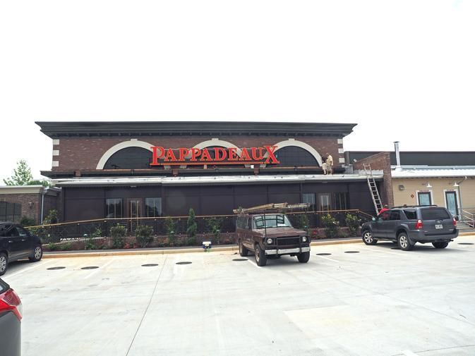 a parking lot in front of a restaurant with cars parked in front of it .