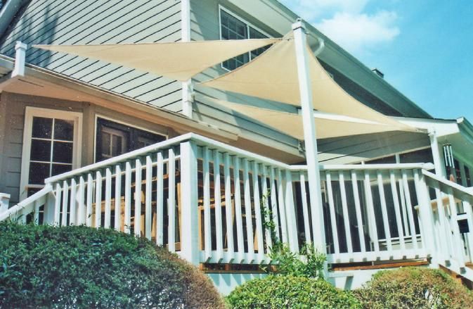 A house with a white railing and a sail on the deck