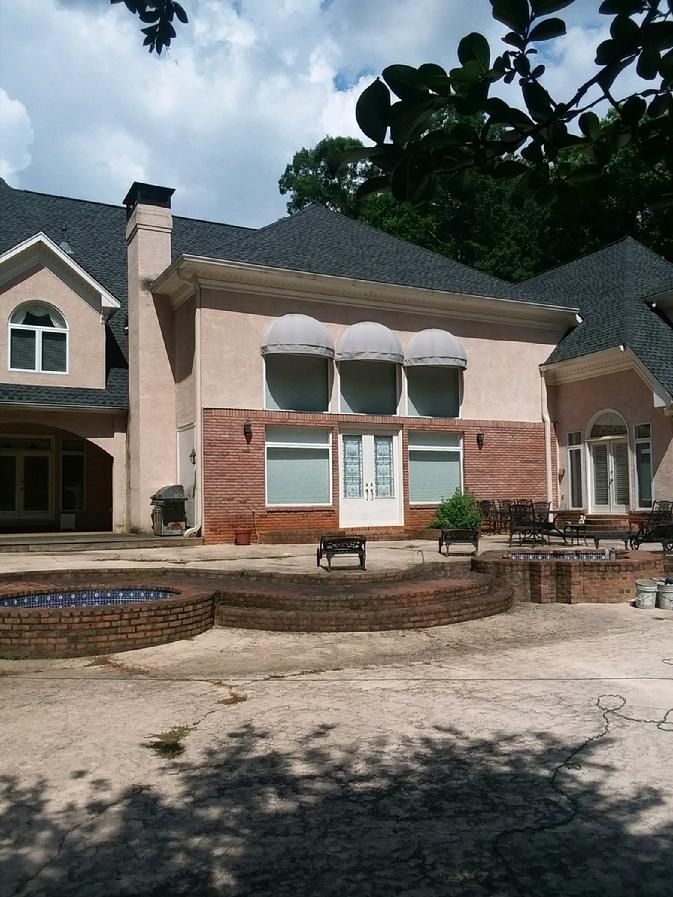 A large house with a swimming pool in front of it