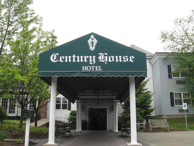 The century house hotel has a green awning over the entrance