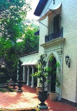 A white building with potted plants in front of it