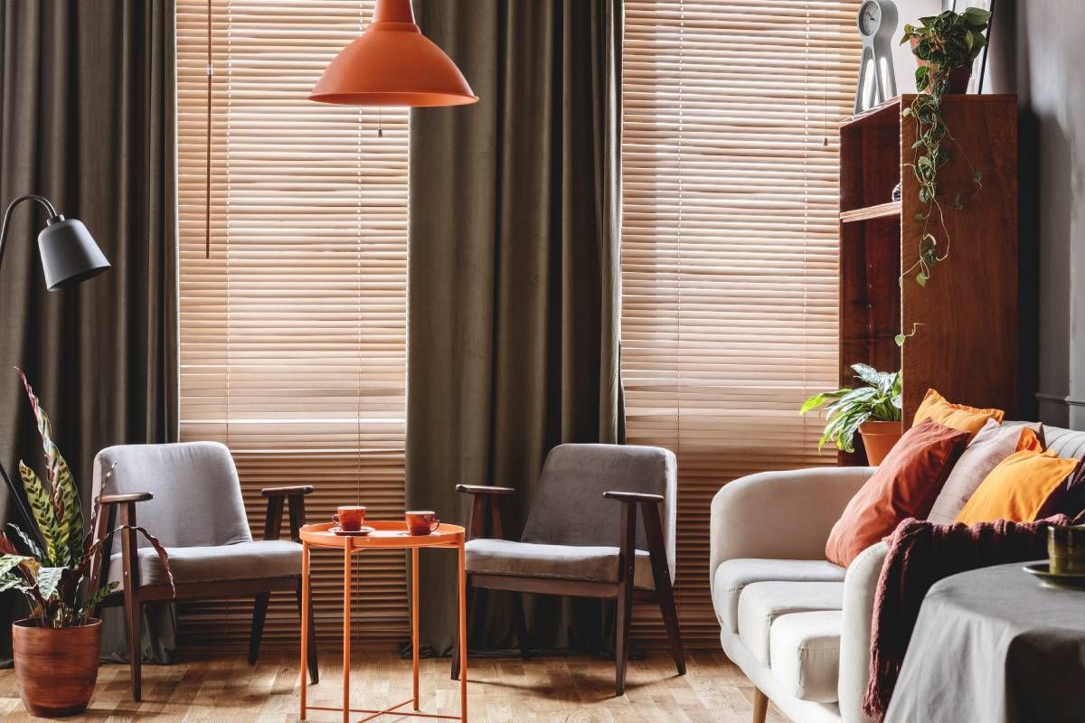 Dark green drapes layered with blinds in a well-decorated dark and retro-style living room