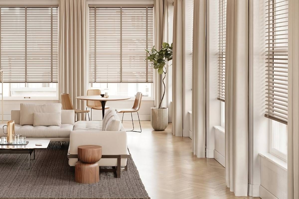 Wood blinds on several large windows in a warm and bright neutral living room