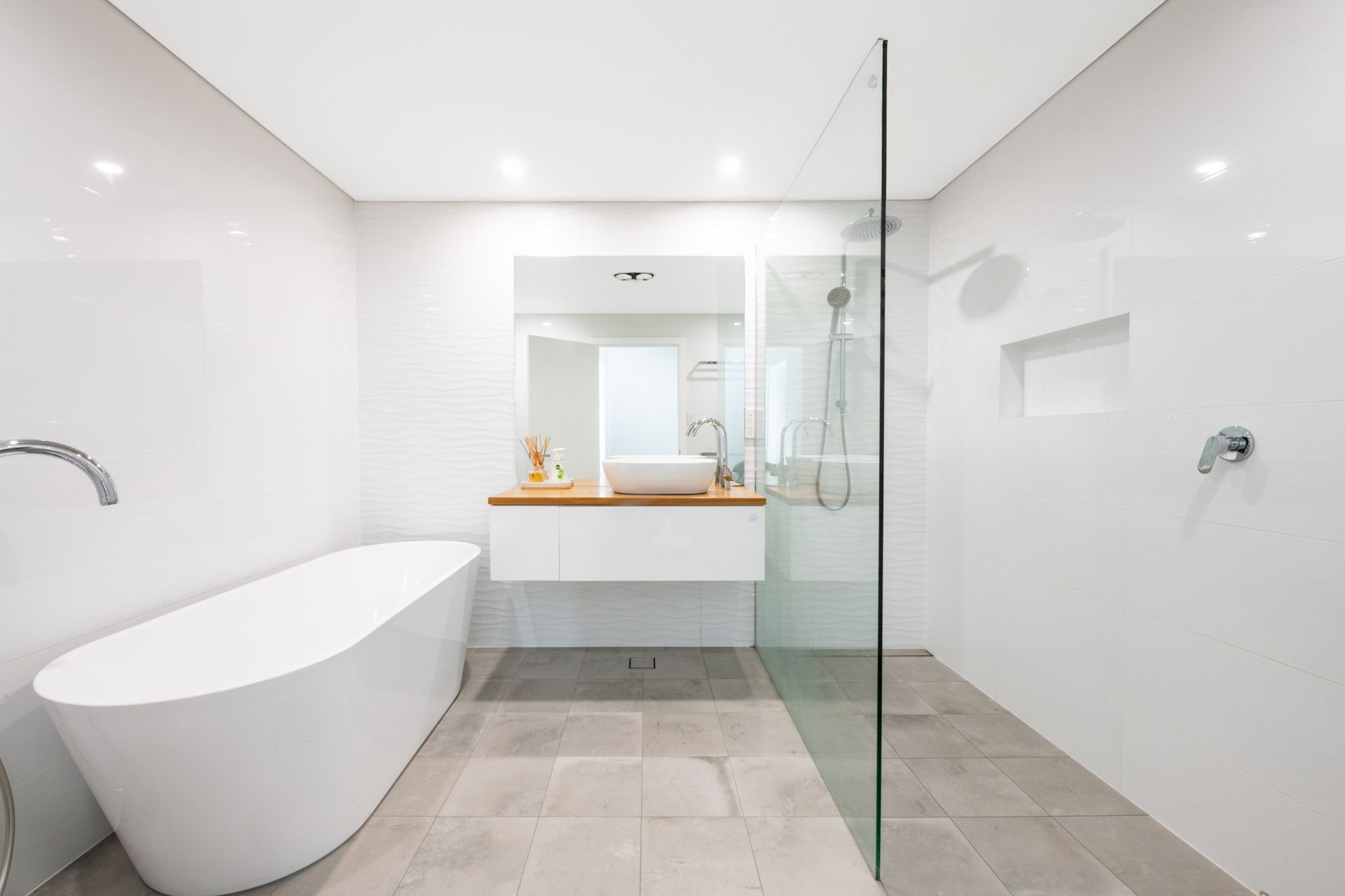 Modern bathroom with glass shower, vanity, and elegant tiling