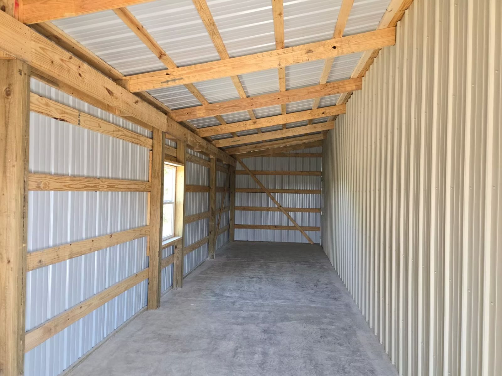 A newly constructed one-story building with dark gray siding, a stone-