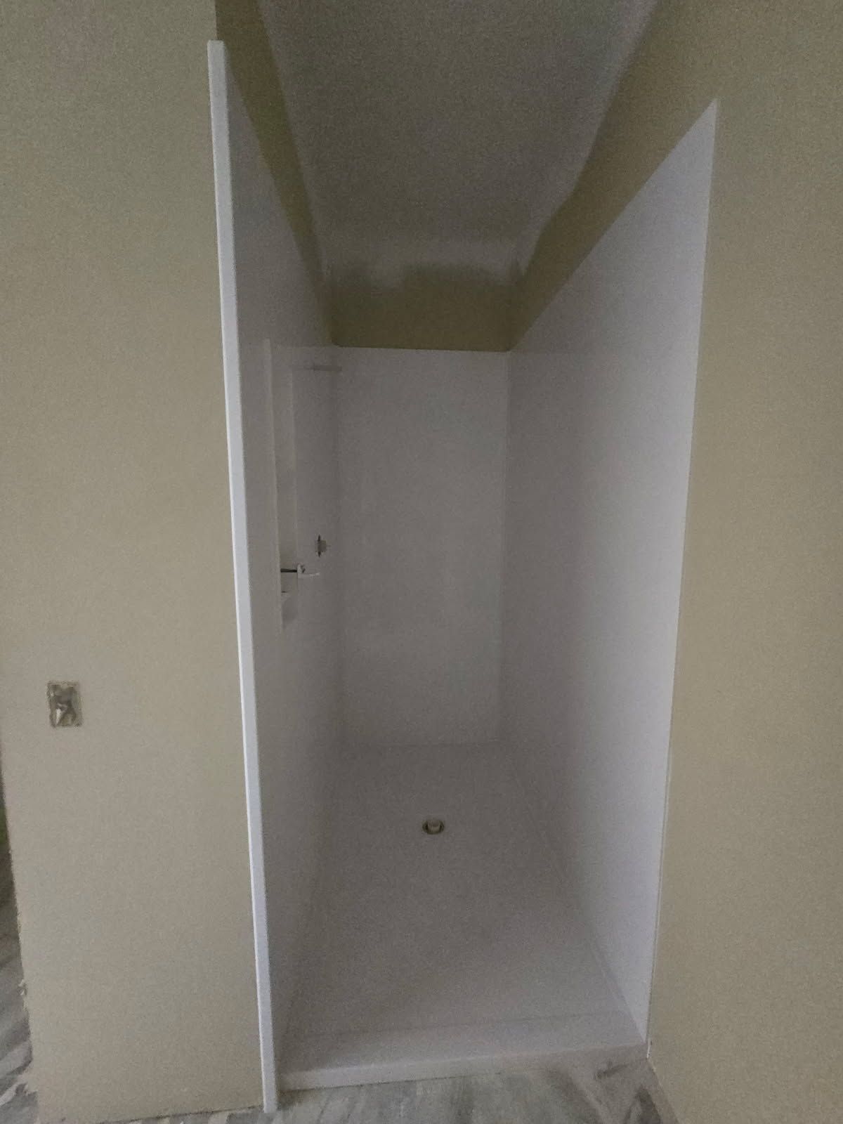 Narrow hallway with beige walls and white doors, viewed from an open doorway.