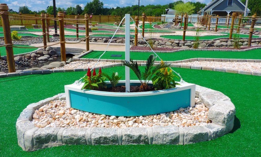 A blue and white boat shaped planter with flowers in it