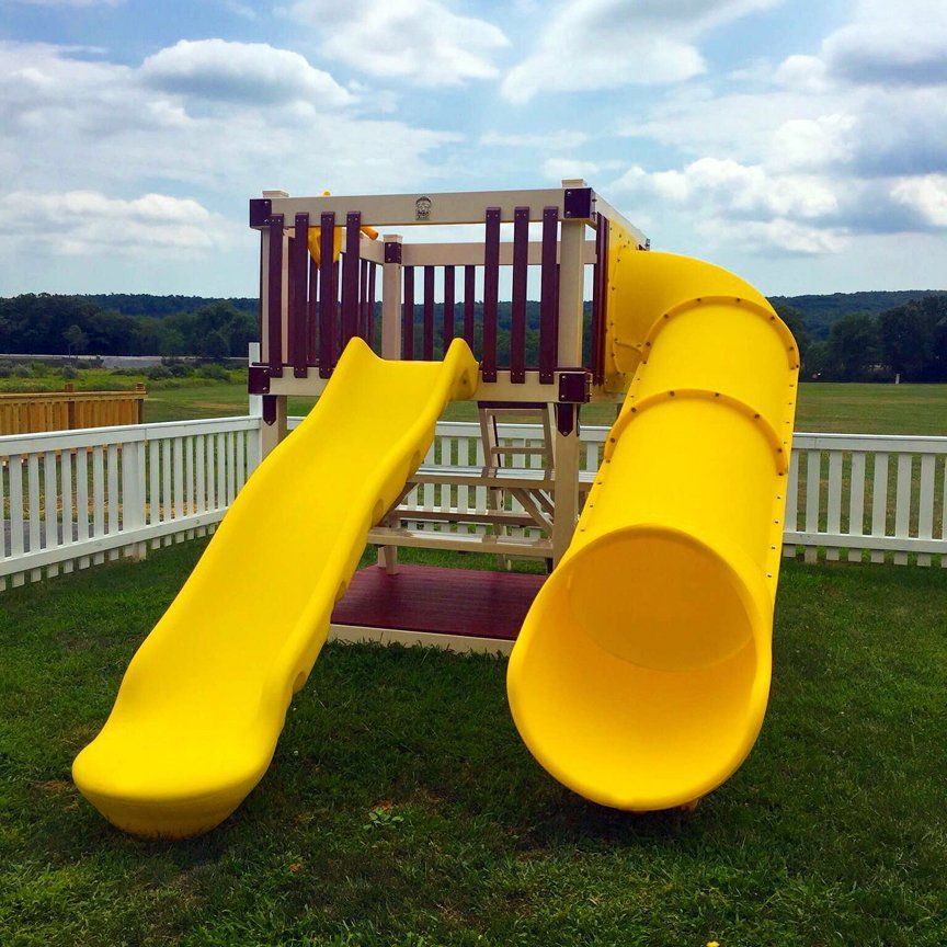 A yellow slide with a white fence in the background