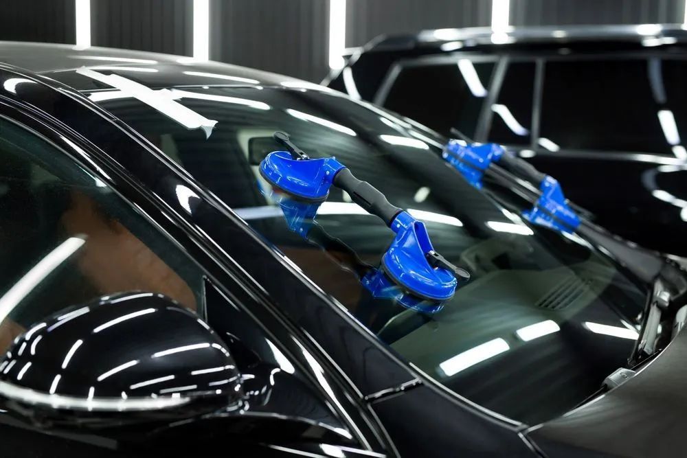Black Car Windshield With Blue Suction Cups — Southern Tablelands Windscreen Repairs in Mittagong, NSW