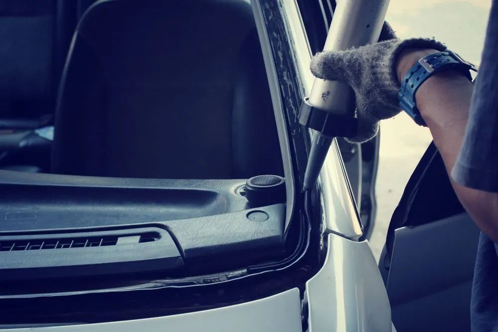 Person Applying Sealant Around a Car Windshield Frame — Southern Tablelands Windscreen Repairs in Mittagong, NSW