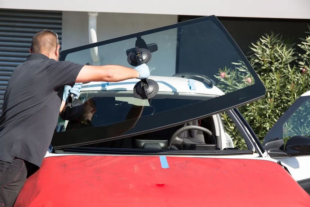 Person Replacing a Car Windshield — Southern Tablelands Windscreen Repairs in Moss Vale, NSW