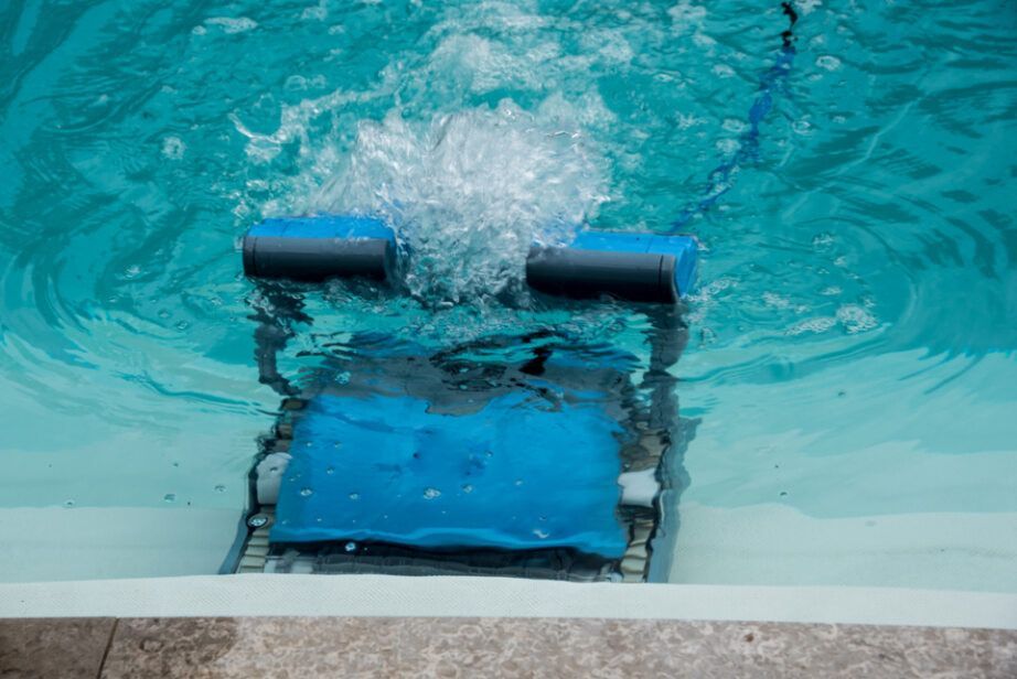 A Robotic Pool Cleaner is Cleaning a Swimming Pool — Tweed Pool Shop in Currumbin, QLD