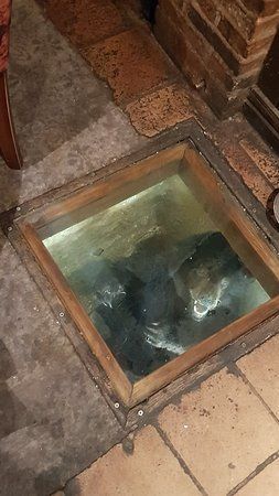 There is a hole in the floor that looks like a fish tank.