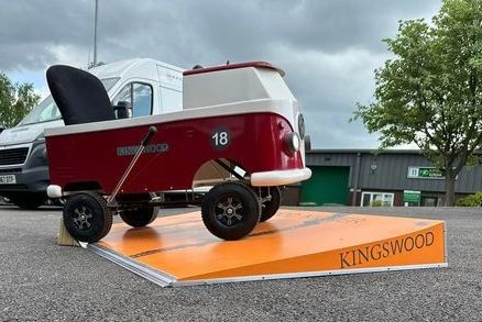 A red and white wagon is sitting on top of an orange ramp.