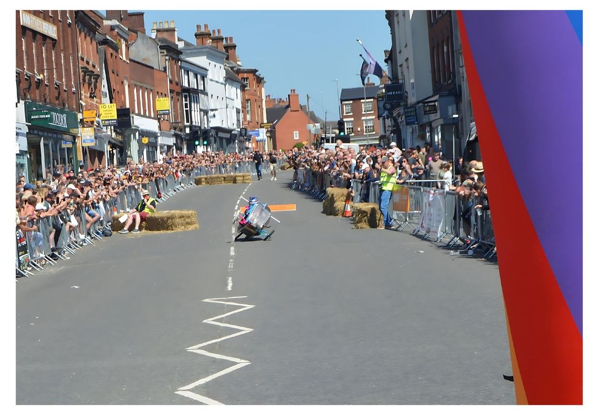 A group of people are watching a race on a street