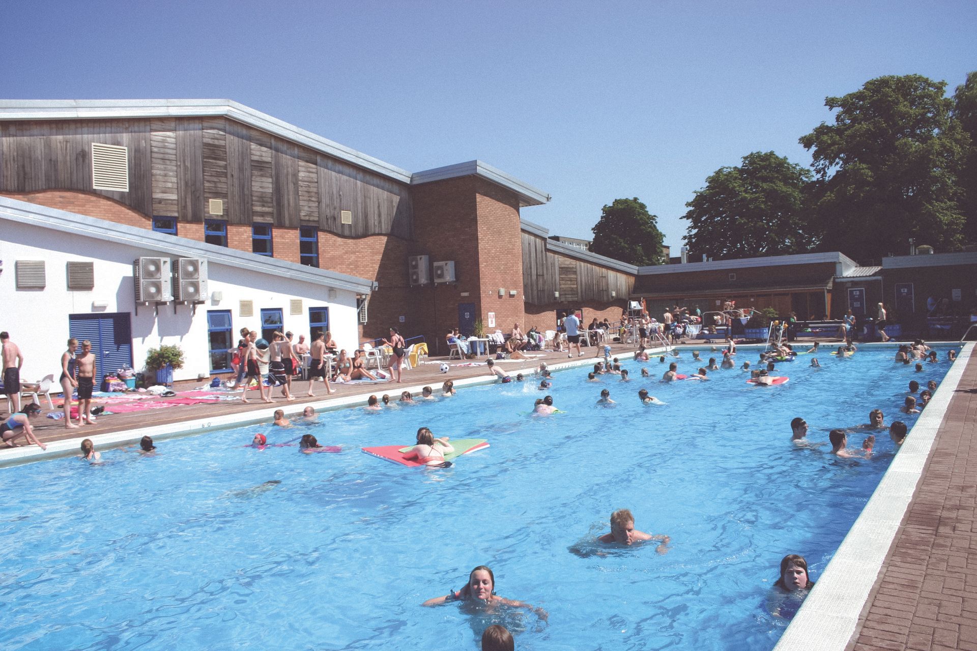 A group of people are swimming in a large swimming pool