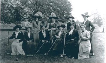 A black and white photo of a group of women playing croquet