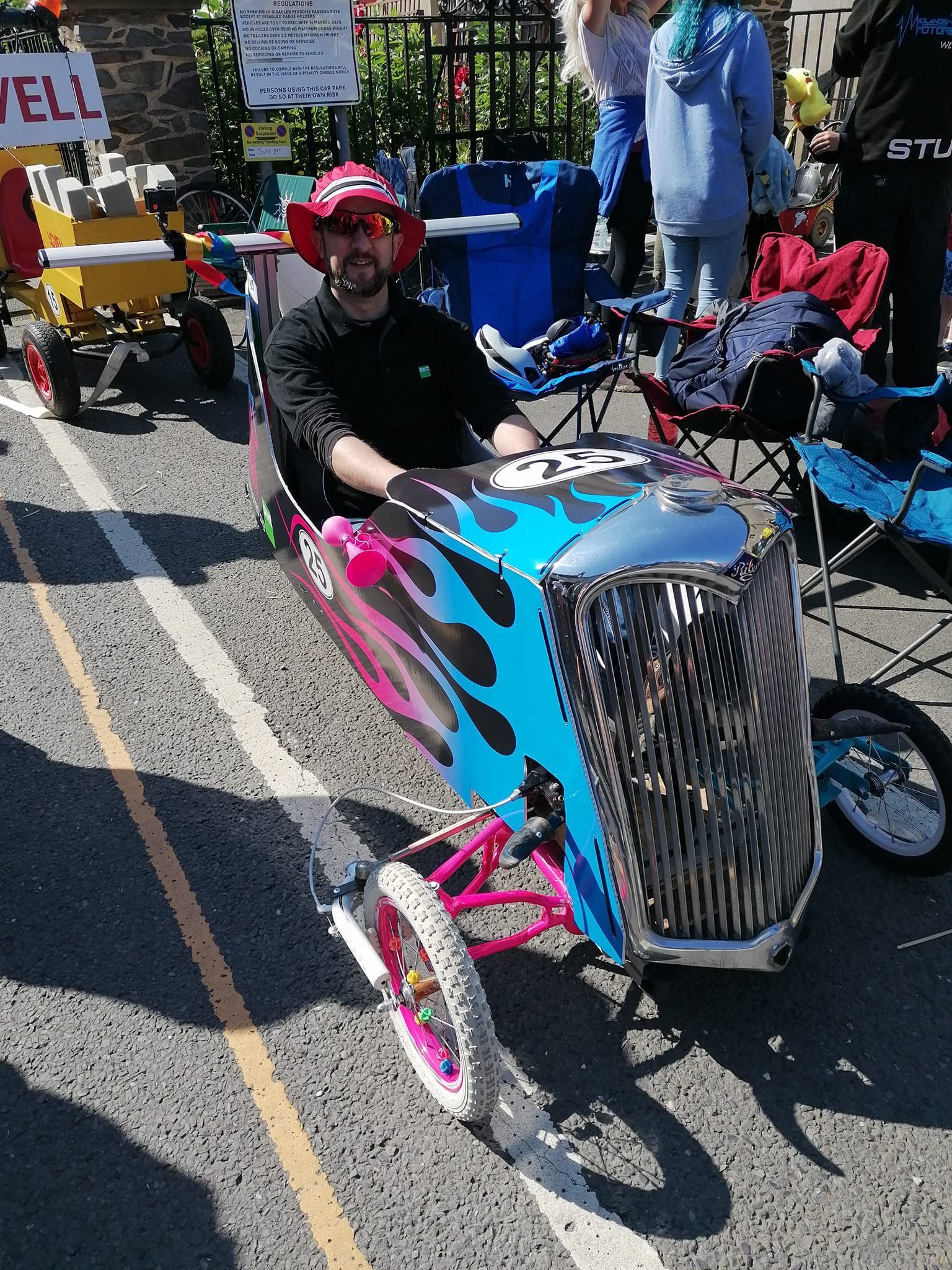 A man is sitting in a car made out of a cardboard box.