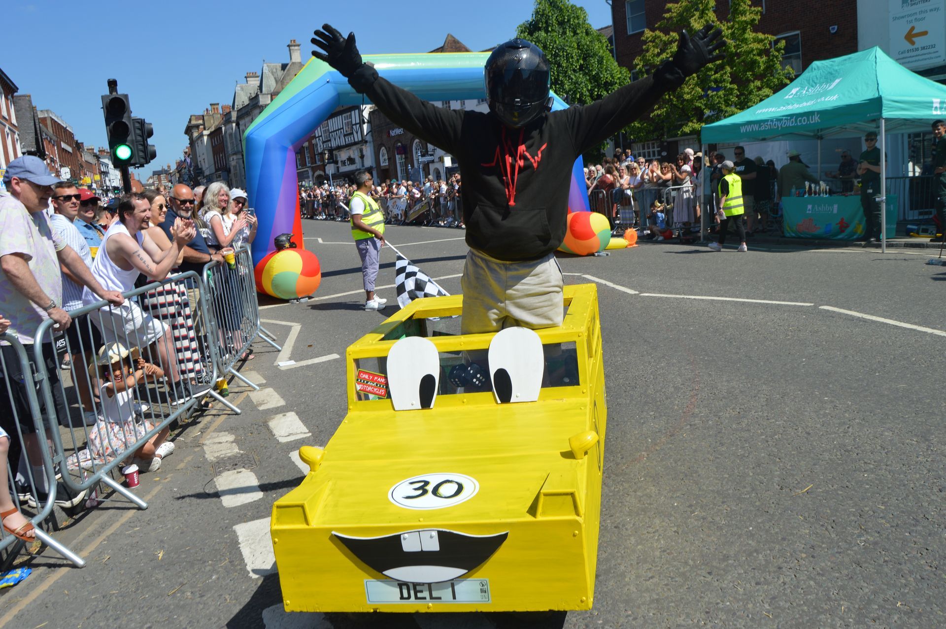 A man in a yellow car with a license plate that says 30