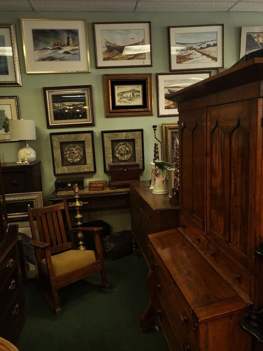 Wooden bed frame leaning against a wall with two framed pictures