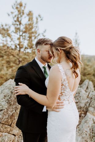 Woman with curly brown and blonde updo hairstyle, adorned with pearl pins.