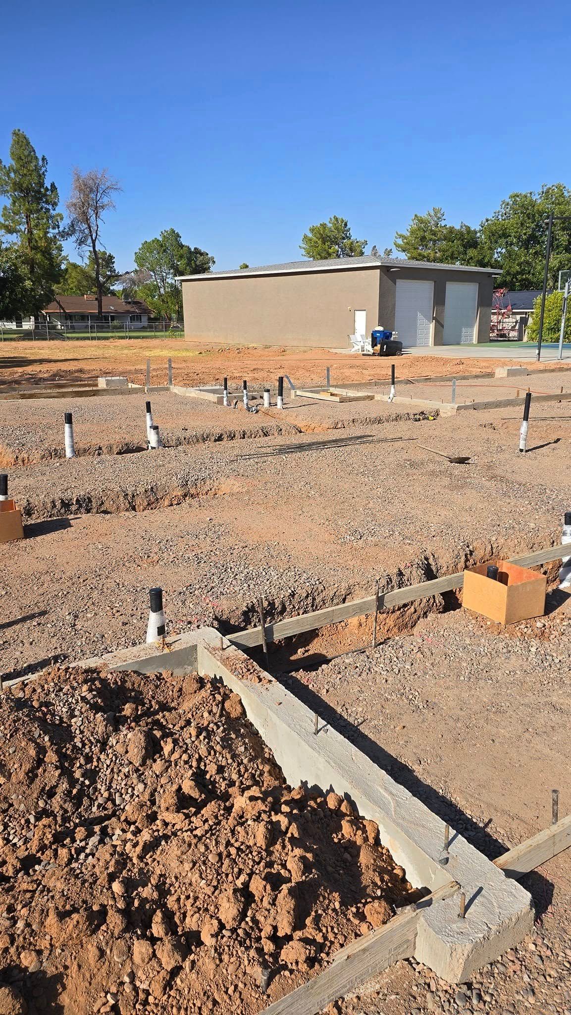 A dirt field with a house in the background.