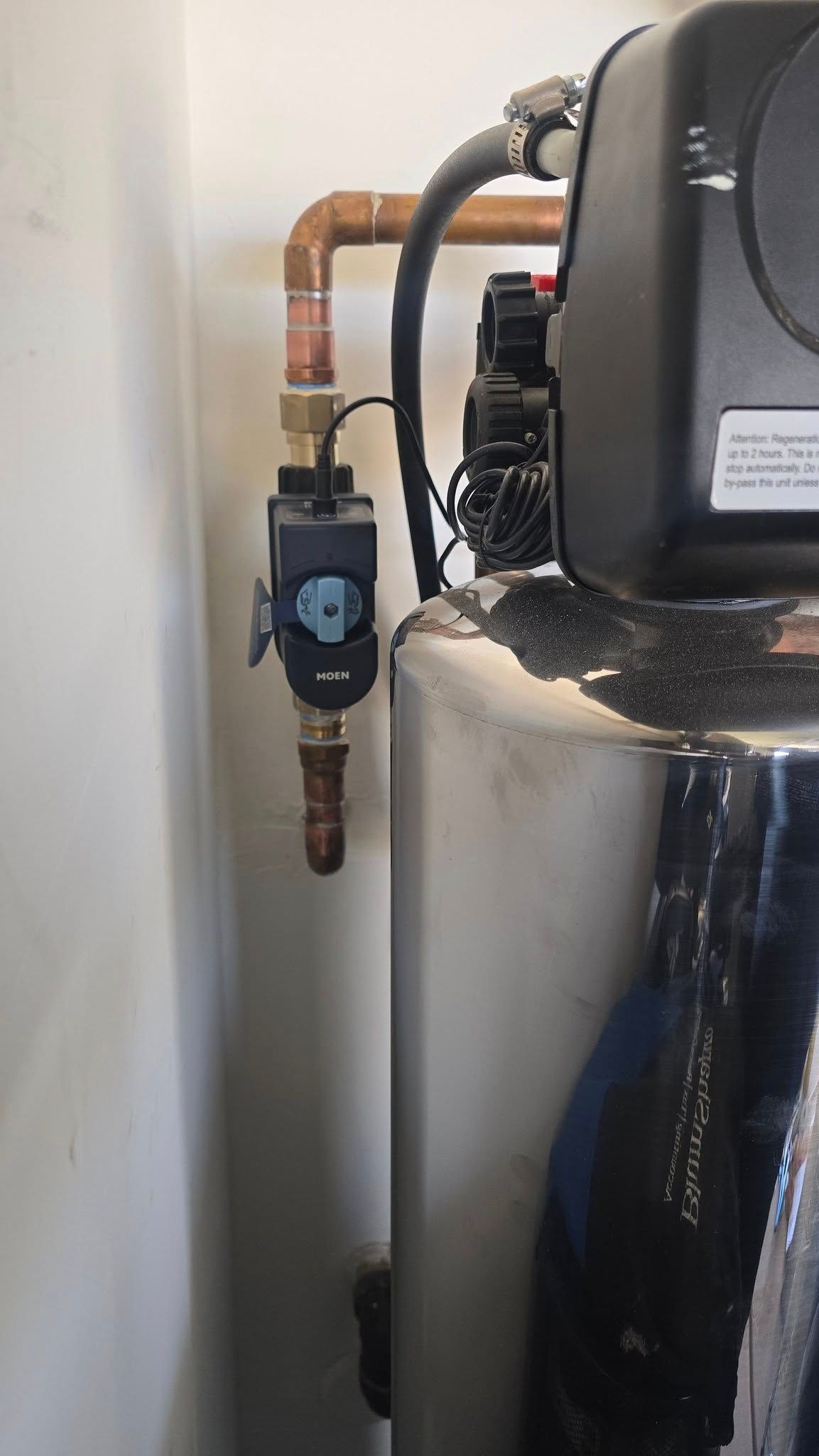 A water heater is sitting next to a wall in a room.
