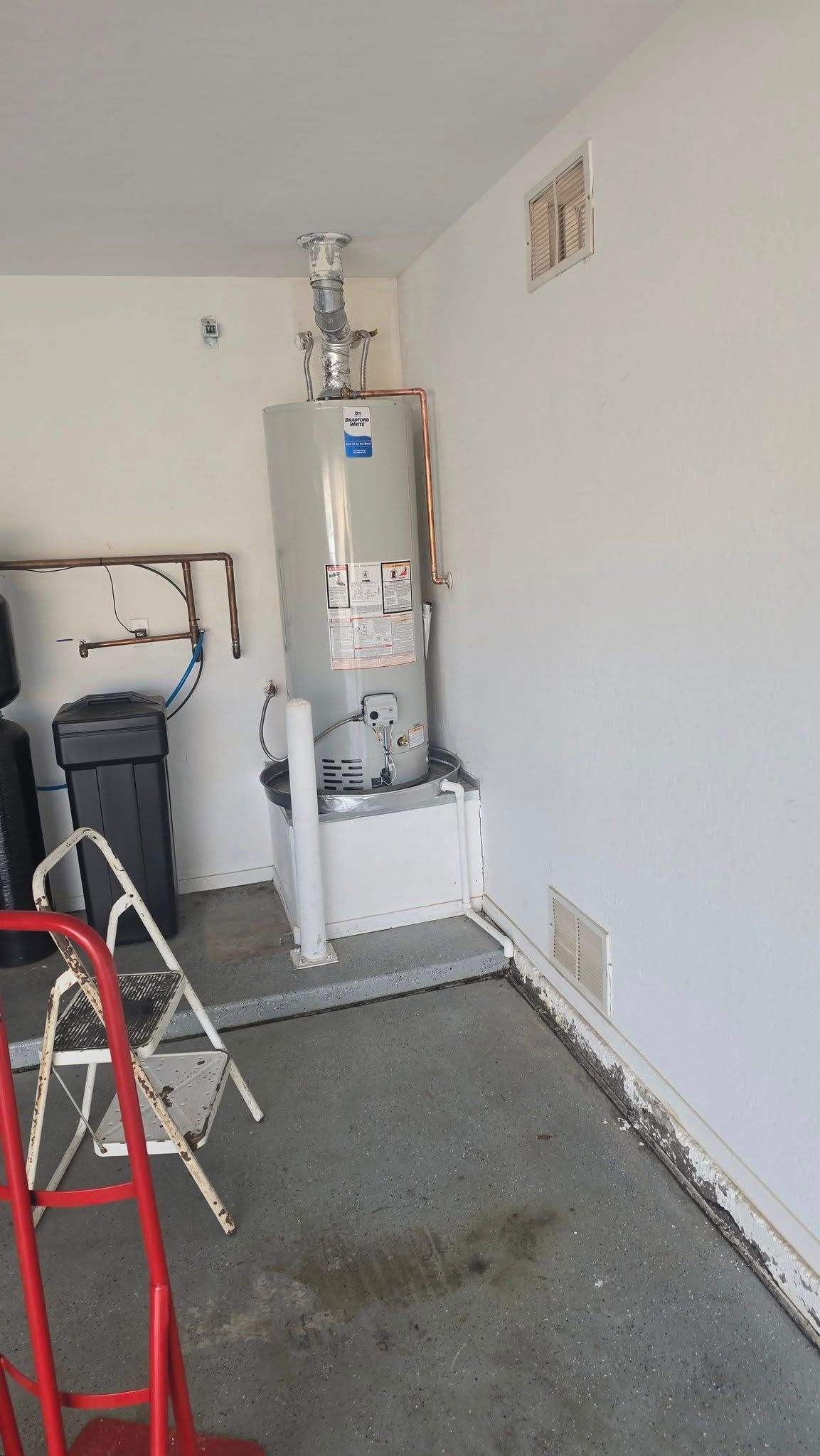 There is a water heater in the corner of the room.