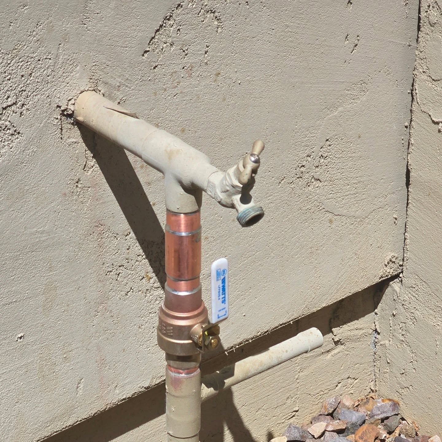 A copper pipe with a blue valve attached to it