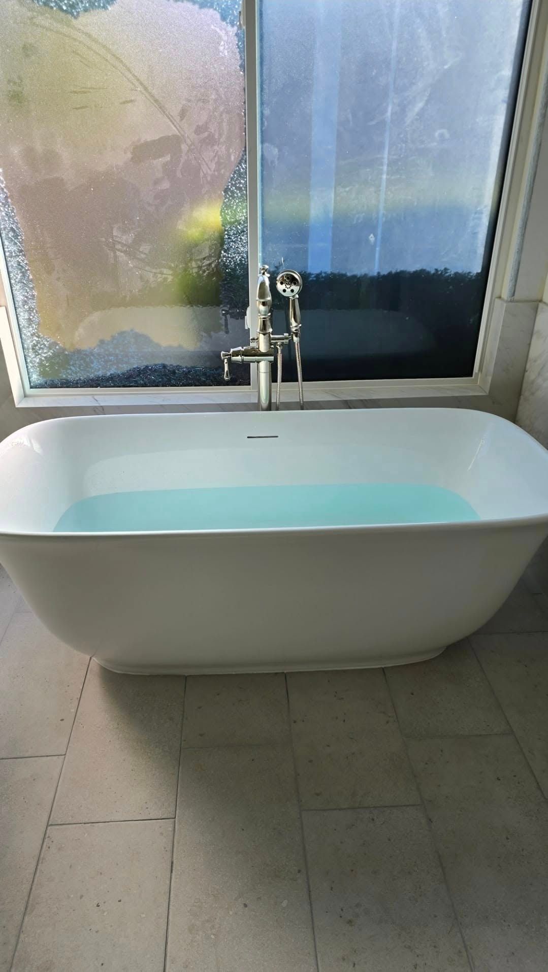A bathtub is sitting in a bathroom next to a window.