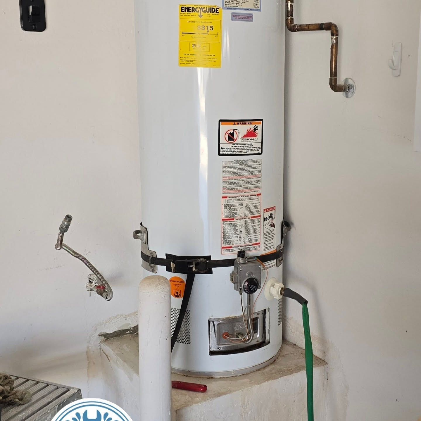 A white water heater with a yellow sticker on it