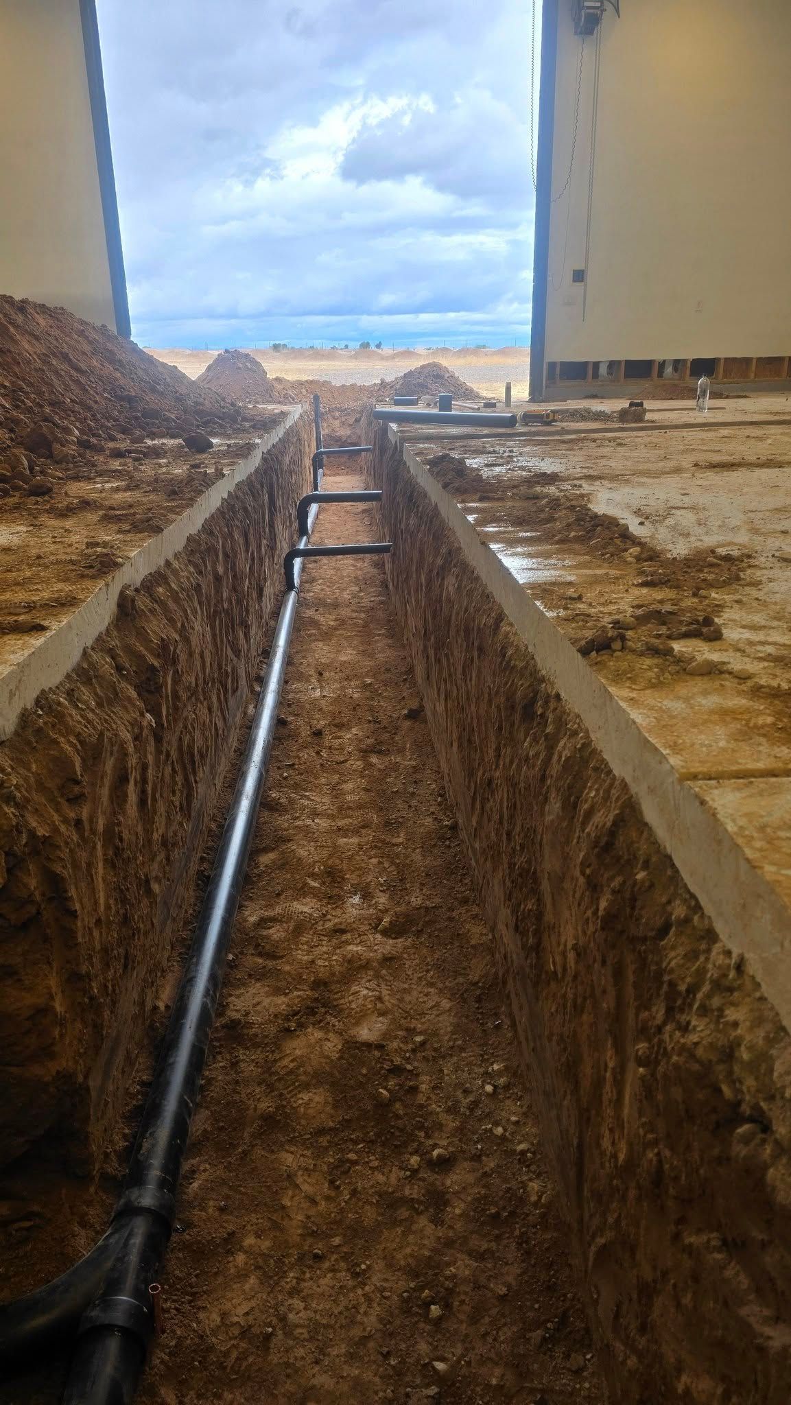 A pipe is being installed in a trench in the dirt.
