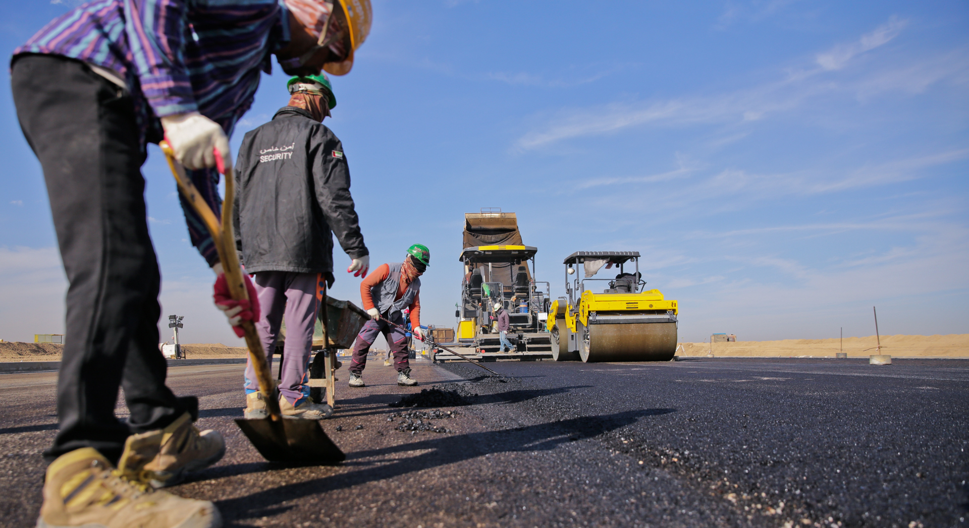 A group of construction workers are working on a road.