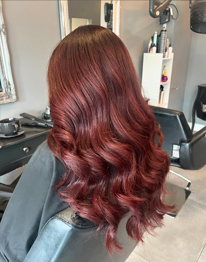 A Woman With Long Red Hair is Wearing a Leopard Print Shirt — Embellish Hair and Beauty In Slade Point, QLD