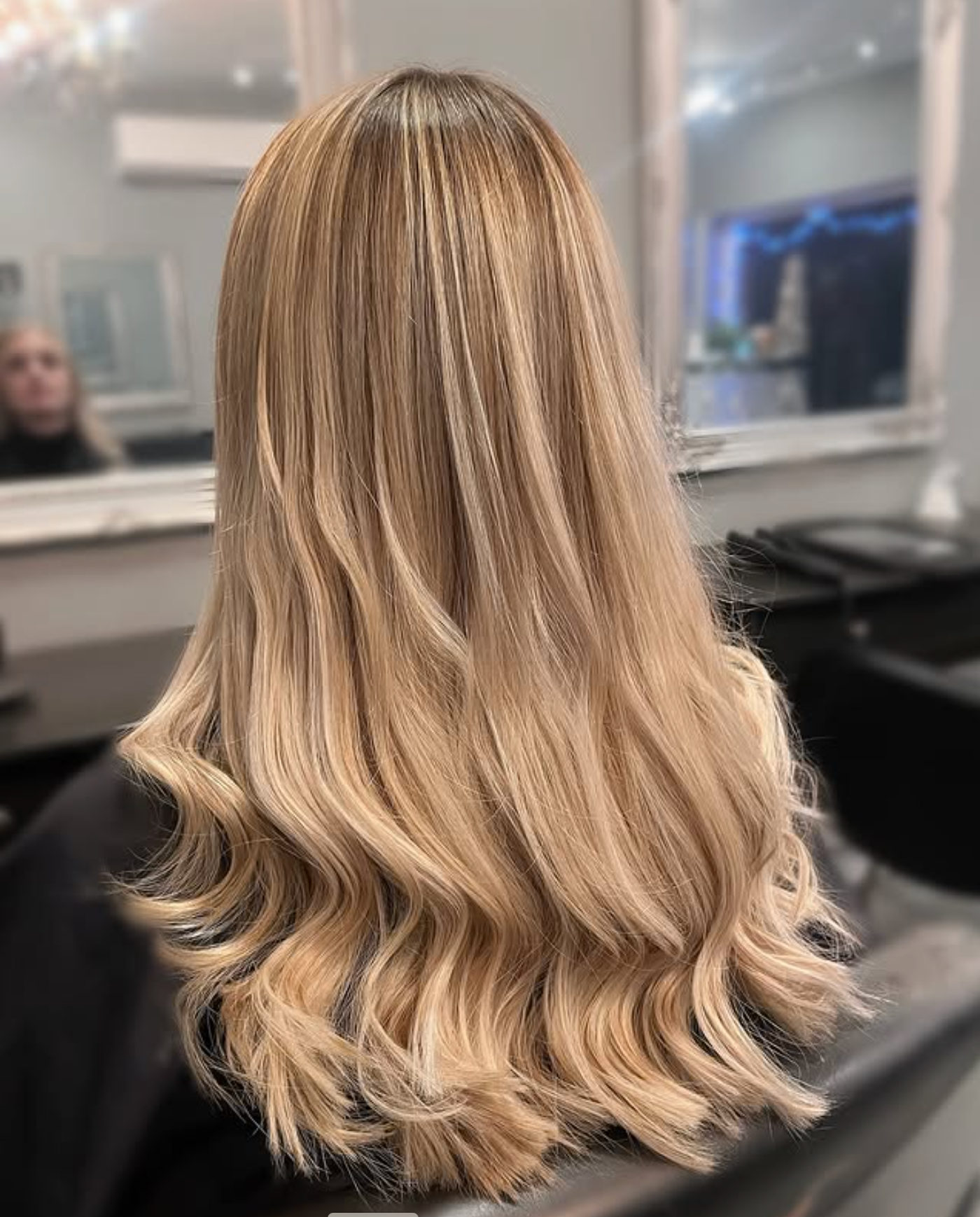 A Woman is Getting Her Hair Dyed in a Salon — Embellish Hair and Beauty In Slade Point, QLD