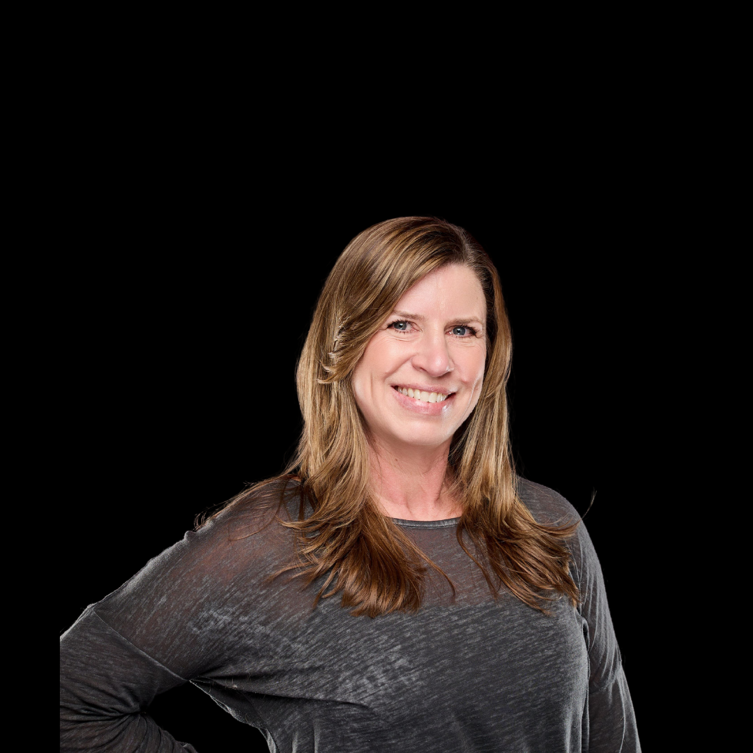 Kelly Foy, Owner & Program Director smiling and standing with her hands on her hips.