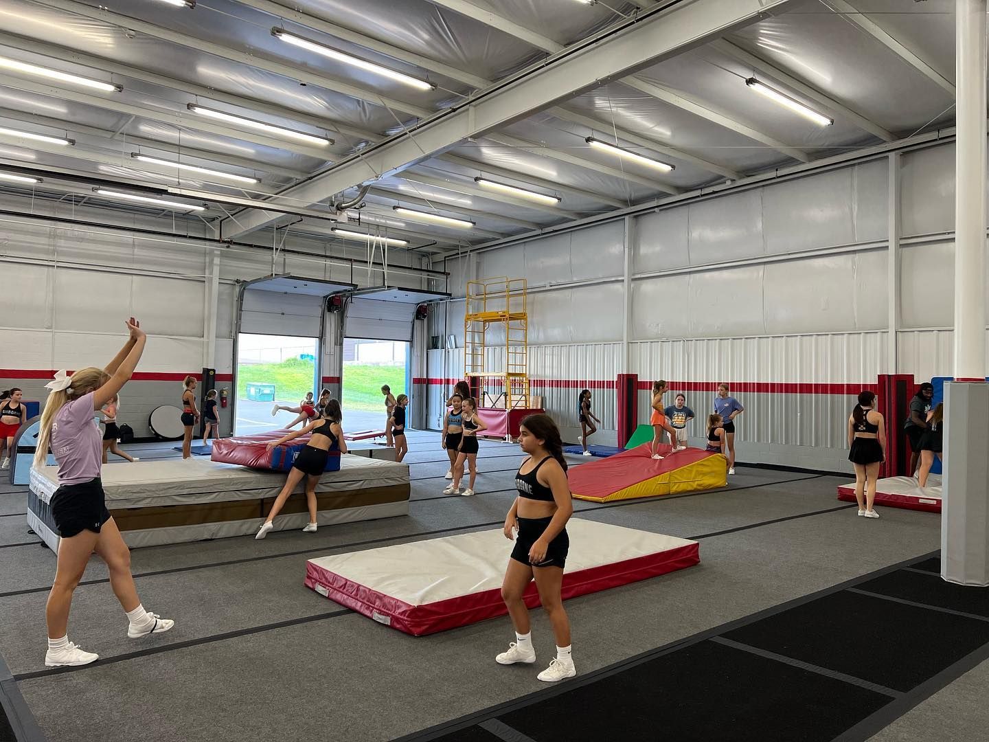 A group of young girls are practicing gymnastics in a gym.