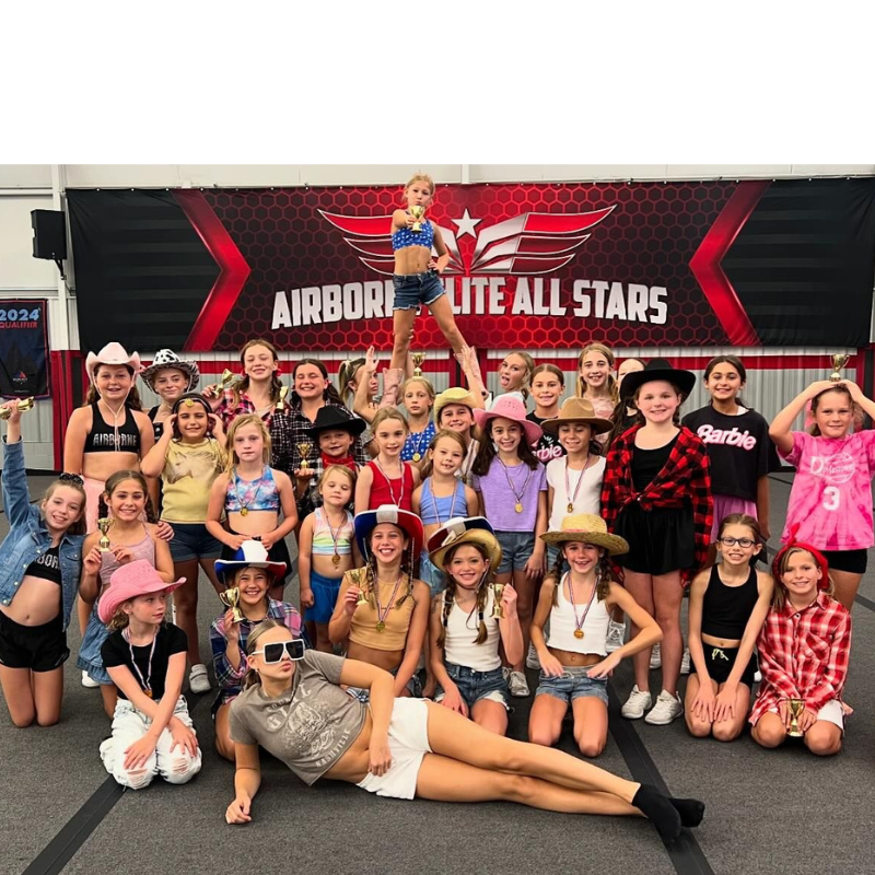 A group of children pose for a picture in front of a sign that says airborne lite all stars