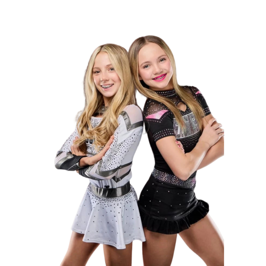 Two young girls standing next to each other with their arms crossed