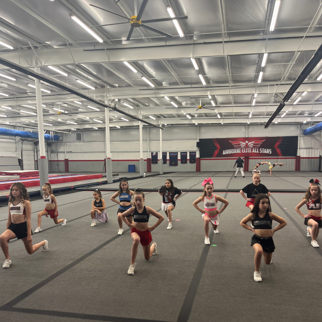 A group of cheerleaders are practicing in a gym