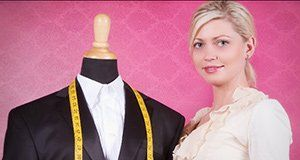 A woman is standing next to a mannequin with a suit on it.