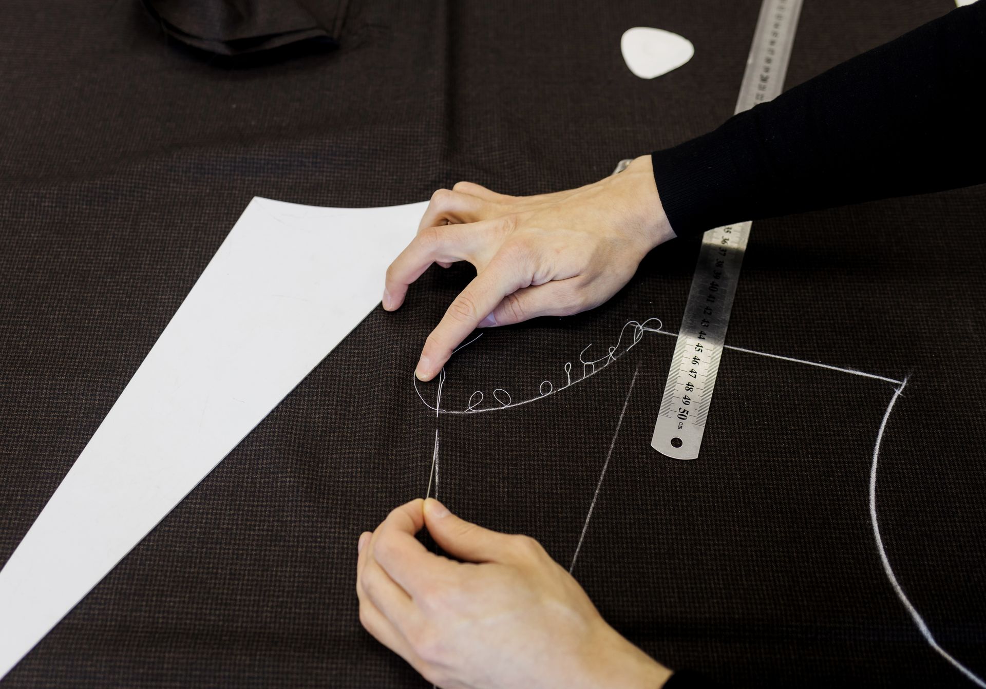 A person is measuring a piece of fabric with a ruler