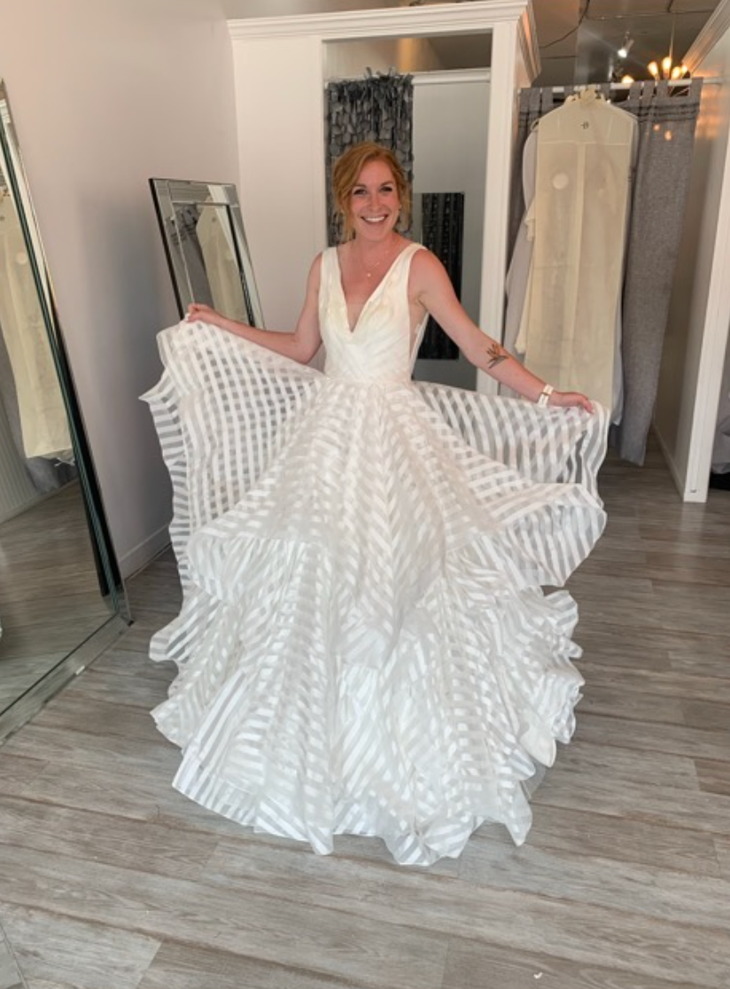 A woman in a wedding dress and veil is standing in front of a mirror.