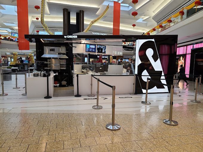 A black and white kiosk in a mall, featuring
