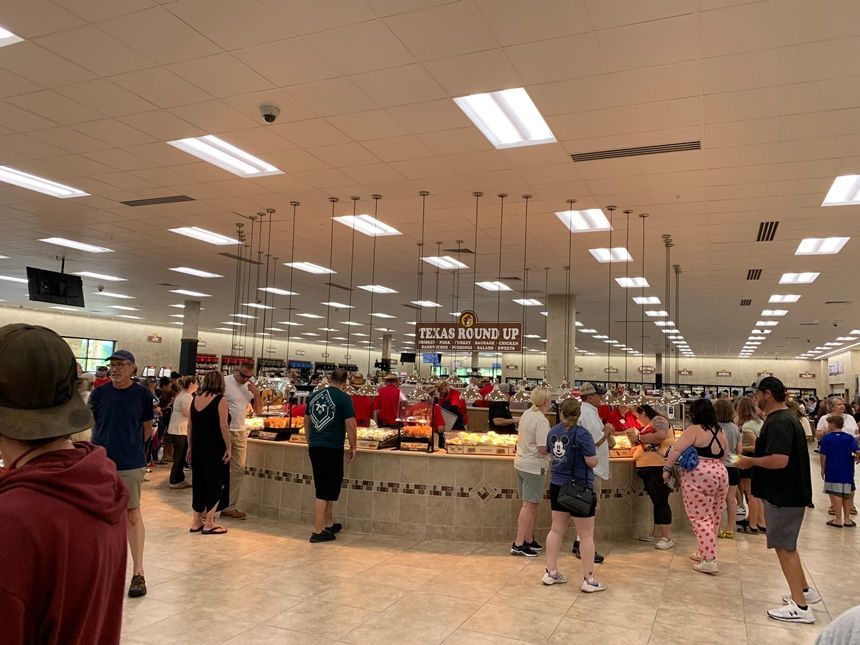 A group of people are standing in a large room.