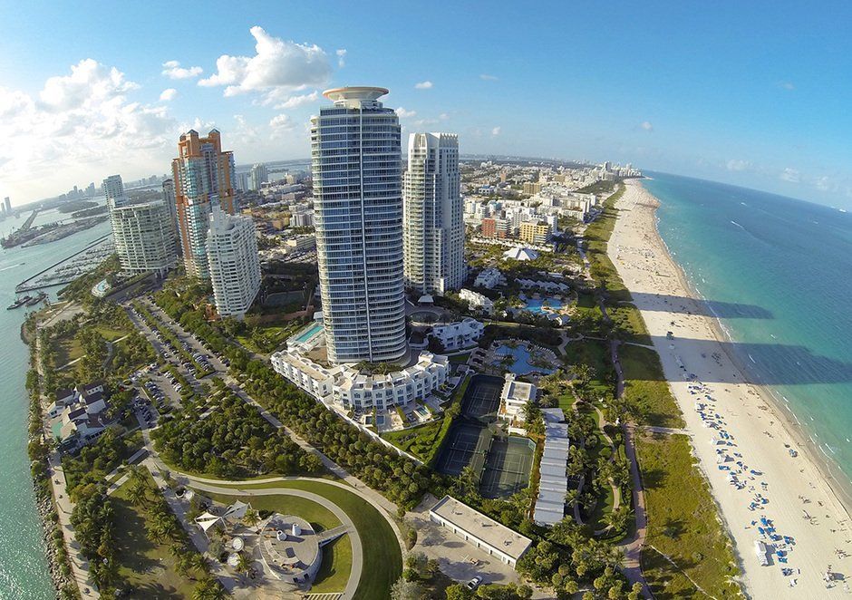 An aerial view of a city with lots of tall buildings and a beach